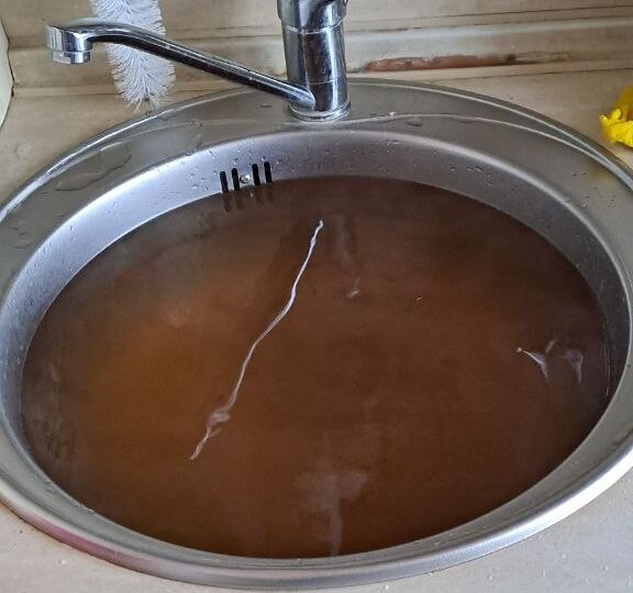 Жители дома на улице Надежды Сусловой целый месяц жалуются на ржавую воду