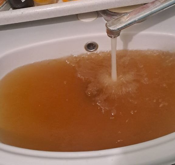 Жители дома на улице Надежды Сусловой целый месяц жалуются на ржавую воду